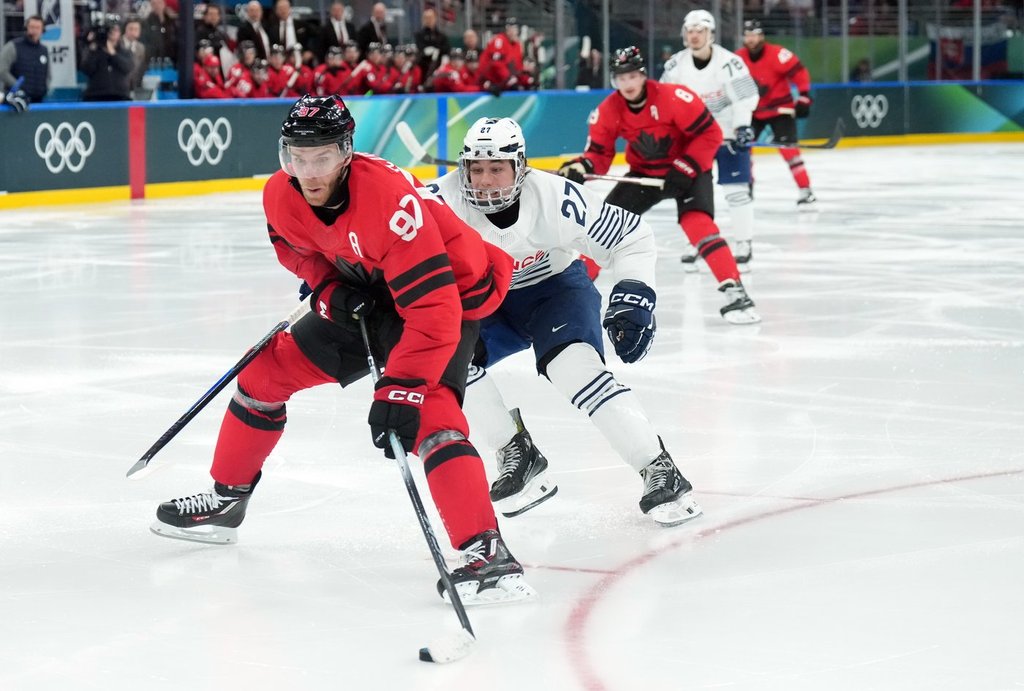 Connor McDavid (97) of Team Canada is chased by Jules Boscq (27) of Team France during third period Olympic hockey action at the 2026 Milan Cortina Winter Olympics in Milan, Italy on Sunday, February 15, 2026. THE CANADIAN PRESS/Nathan Denette.
