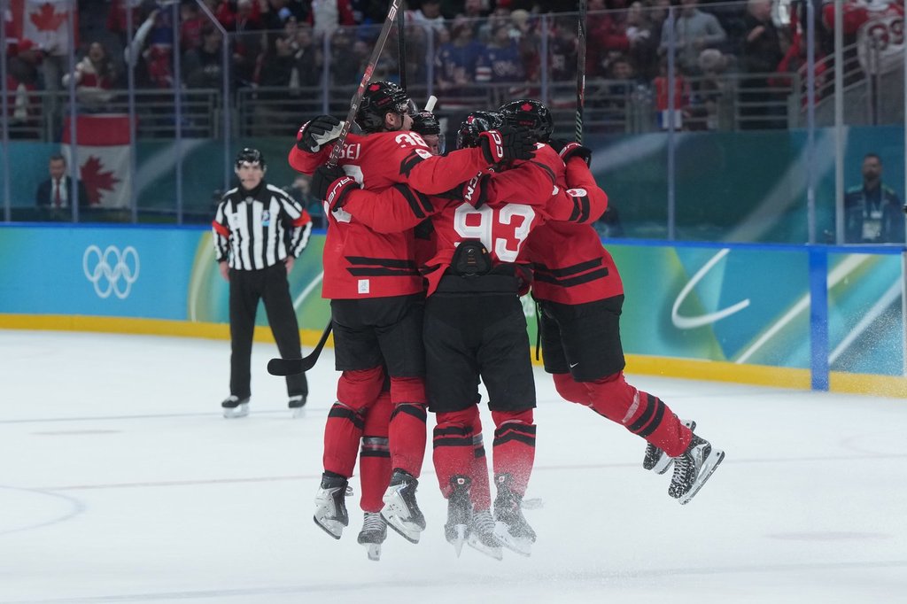 Team Canada players celebrate Canada's Mitch Marner's game-winning goal during overtime of a quarterfinal men's hockey game at the 2026 Winter Olympics, in Milan, on Wednesday, Feb. 18, 2026. THE CANADIAN PRESS/Darryl Dyck.