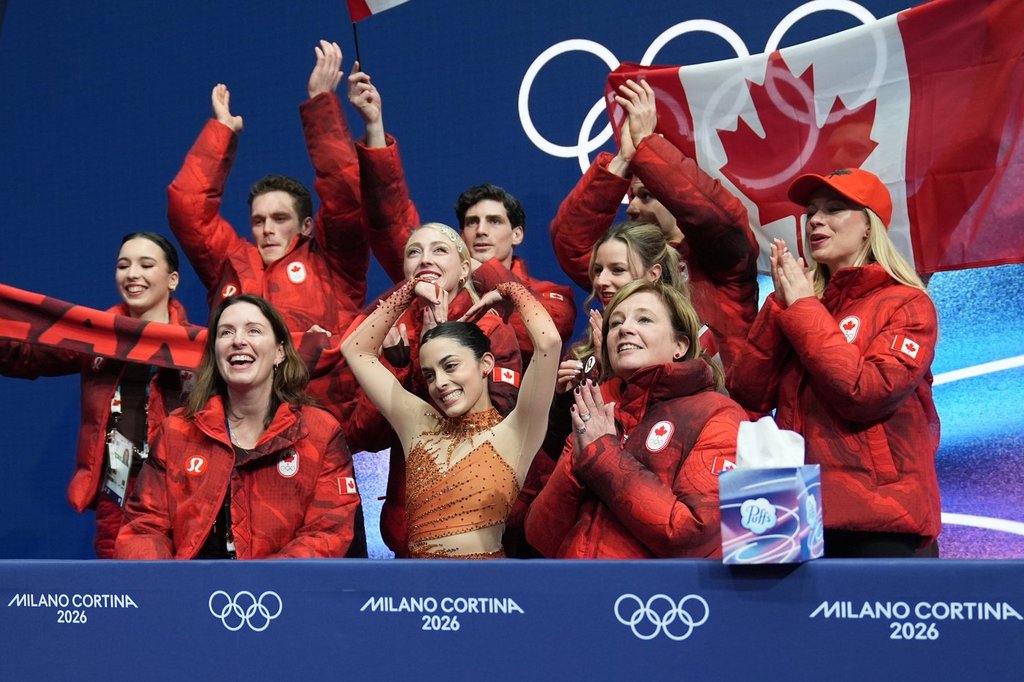 Madeline Schizas, center, of Canada reacts to her scores after competing during the figure skating women's team event at the 2026 Winter Olympics, in Milan, Italy, Friday, Feb. 6, 2026. (AP Photo/Stephanie Scarbrough).