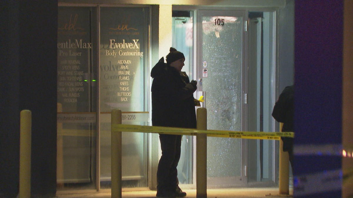Calgary police could be seen examining a shattered glass door in one of the buildings that was surrounded by police tape following the shooting.
