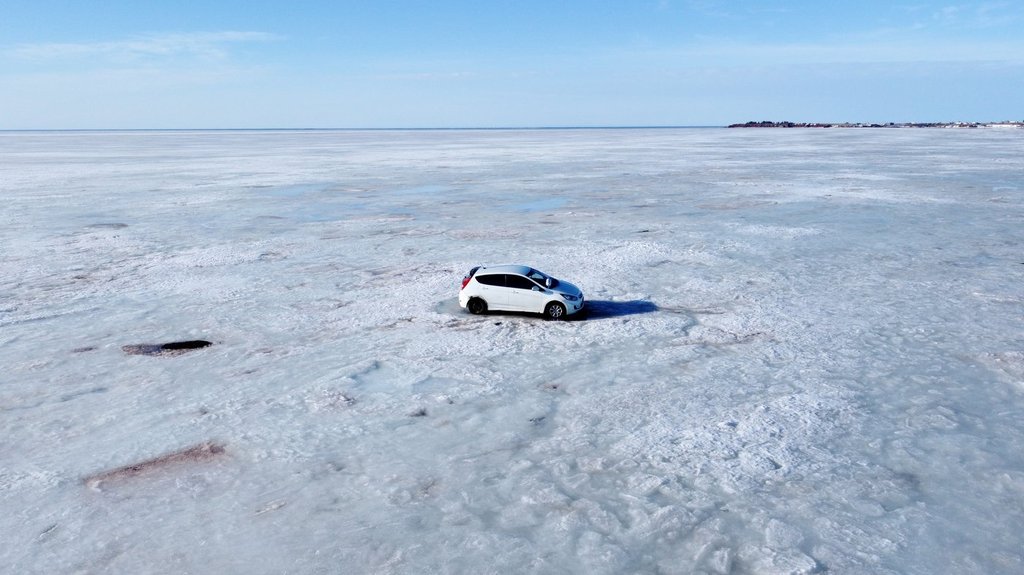 Abandoned car retrieved from ice off Nova Scotia shore by helicopter, snowmobiles