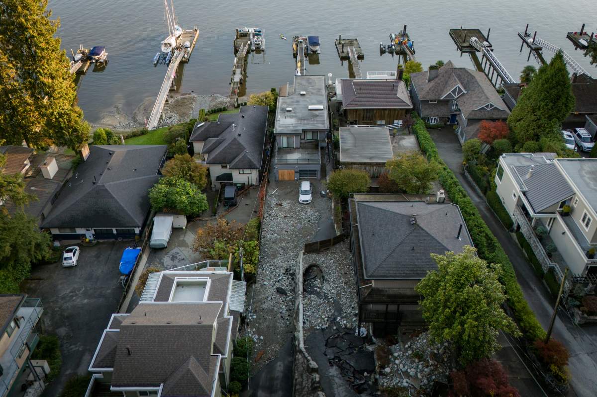 Multiple homes are seen surrounded by debris left by flooding from torrential rain from an atmospheric river weather system at Deep Cove in North Vancouver, on Tuesday, October 22, 2024.