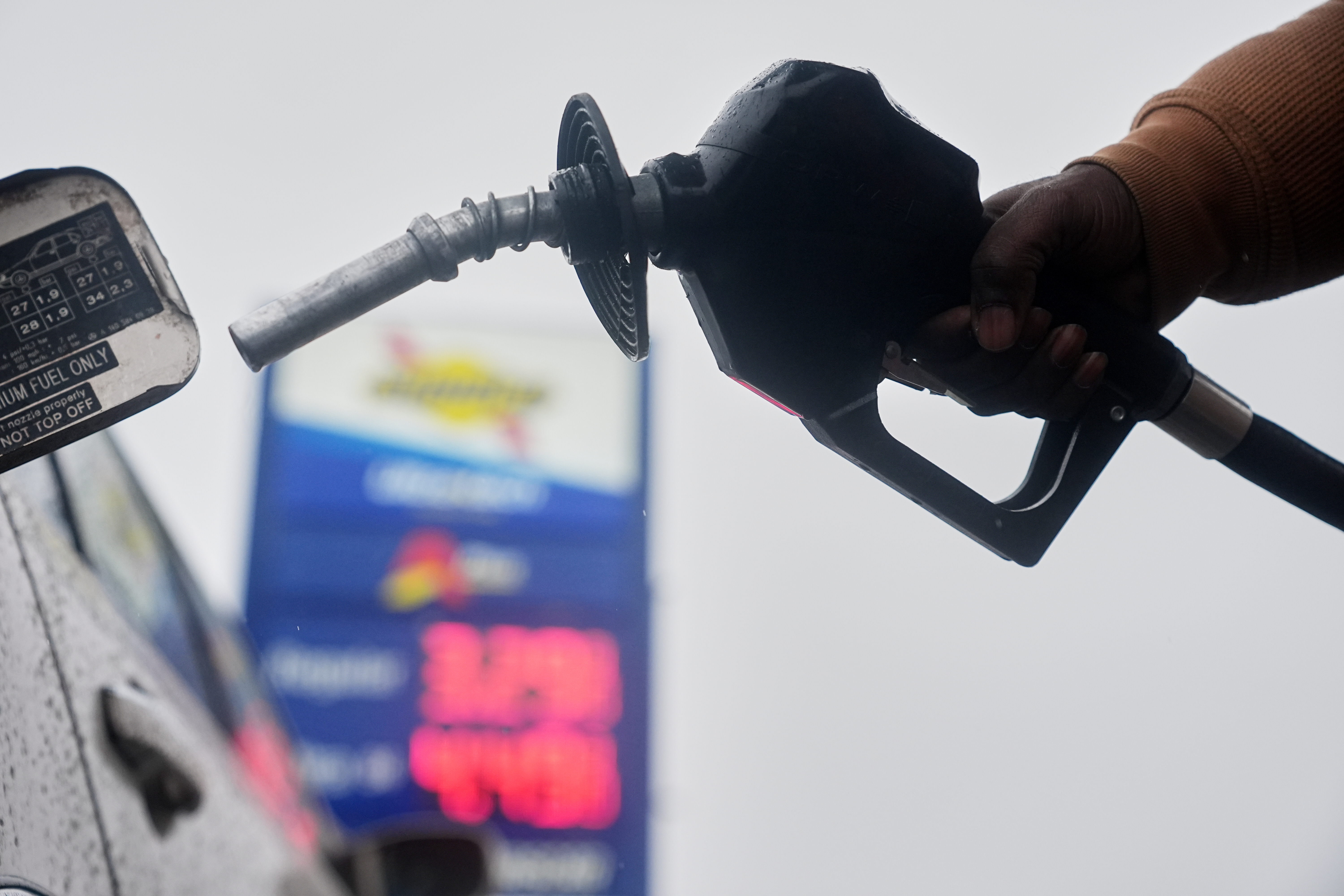 A motorist removes the pump from his car at a gas station, in Philadelphia, Tuesday, March 3, 2026.