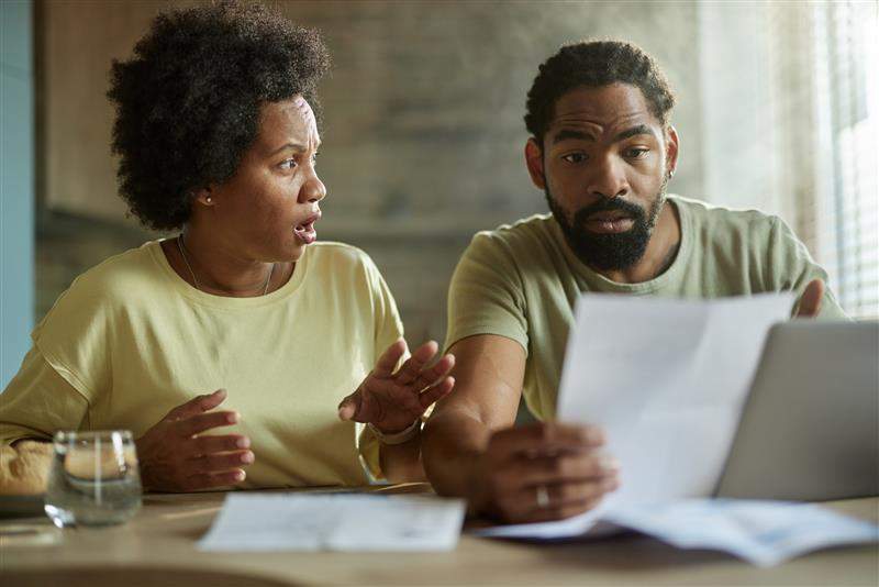 A couple is in disbelief after receiving a denial letter from their insurer. Skynesher/Getty Images