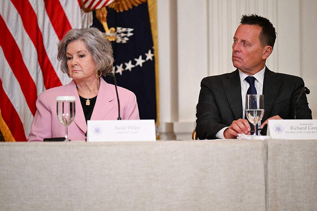 (L/R) White House Chief of Staff Susie Wiles and Richard Grenell, outgoing President of The Kennedy Center Board of Trustees, look on as US President Donald Trump speaks during a lunch with the Kennedy Center Board Members in the East Room of the White House on March 16, 2026 in Washington, DC.