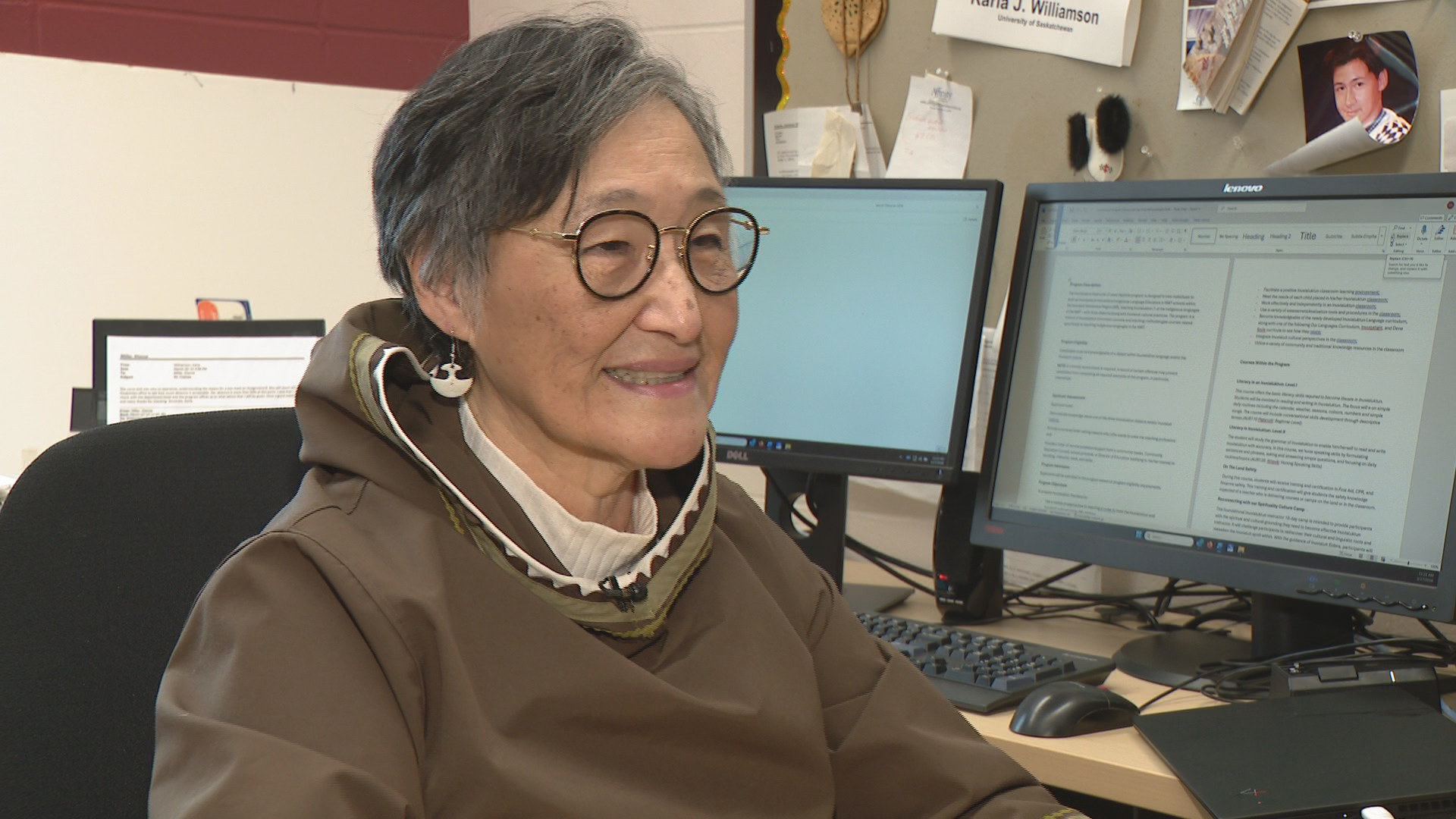 A woman sits behind her desk.