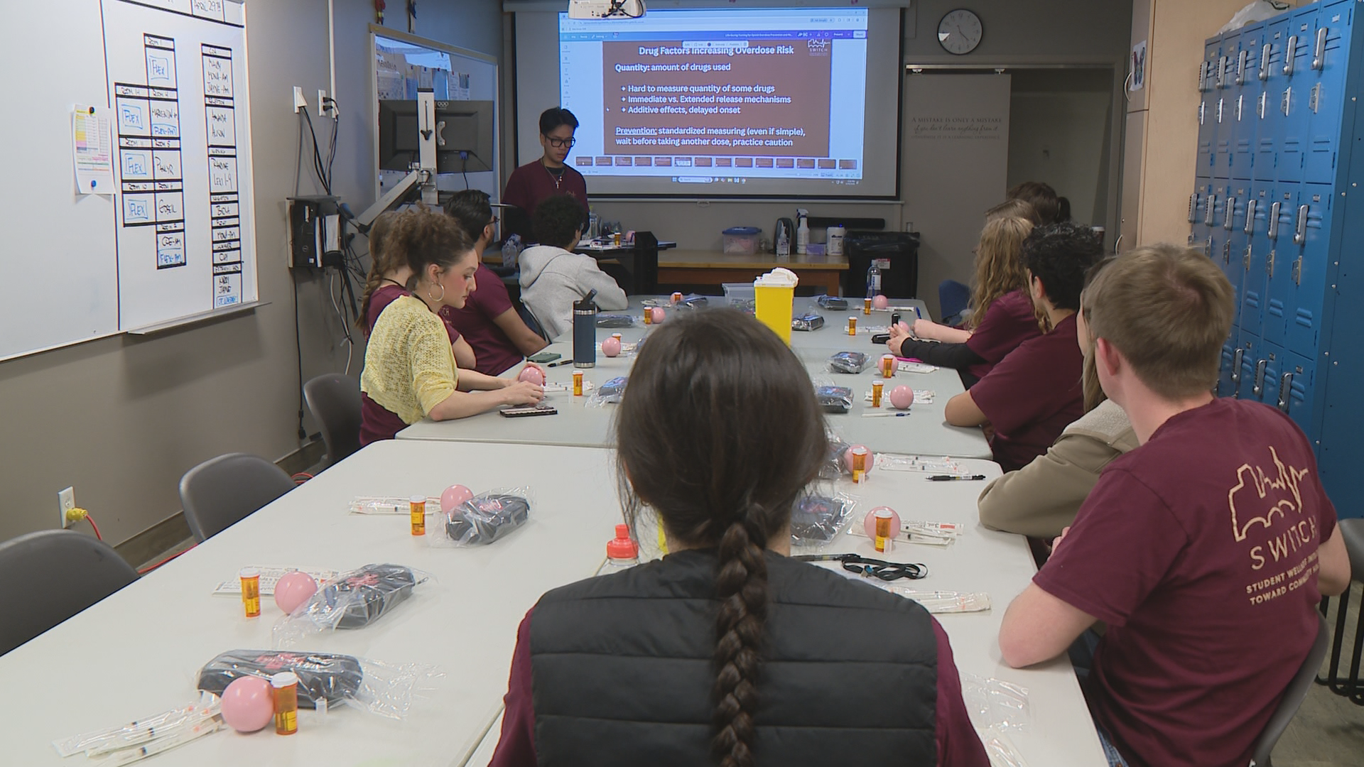 Students sit at a table to learn about administering naloxone.