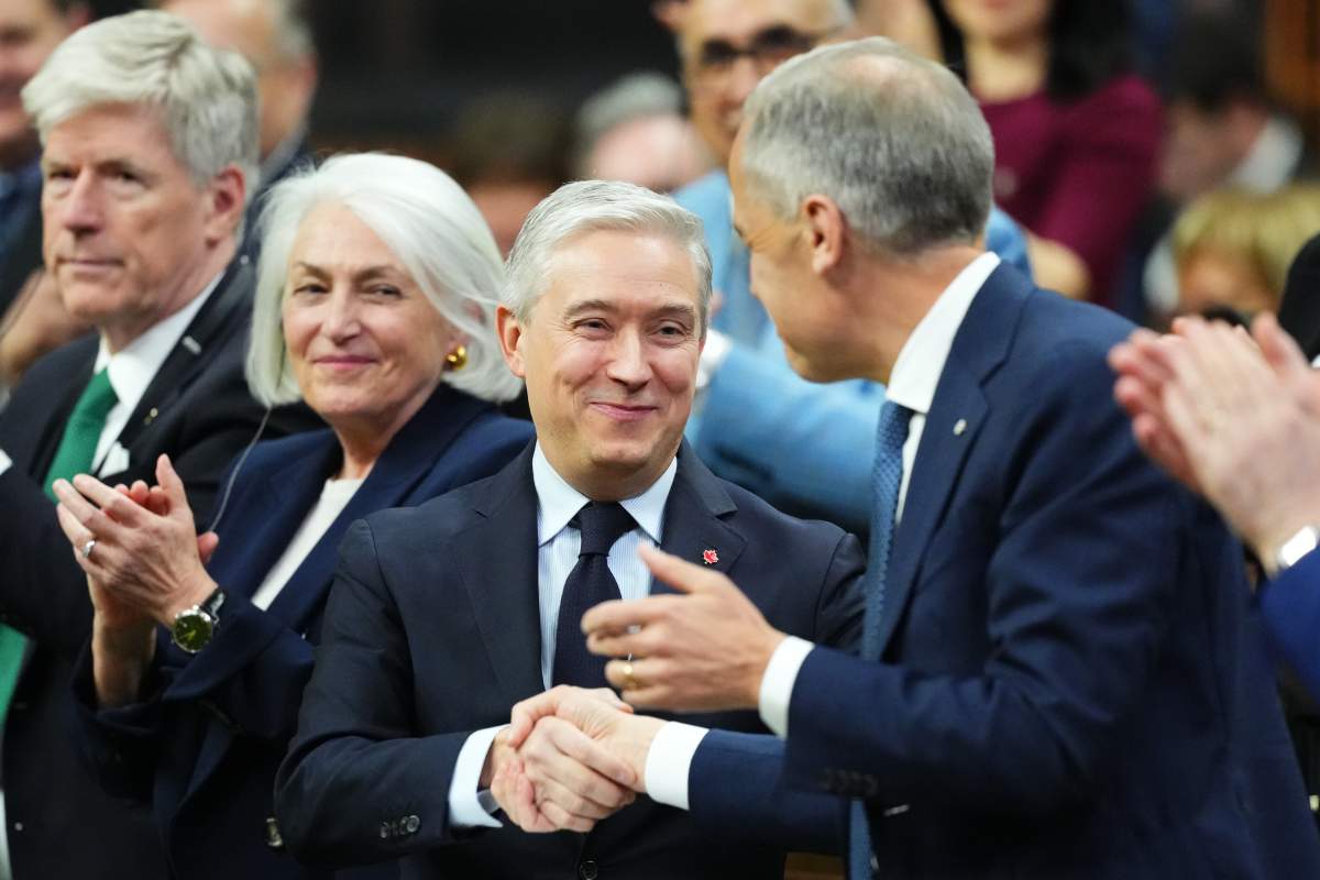 Finance and National Revenue Minister Francois-Philippe Champagne, left, shakes hands with Prime Minister Mark Carney