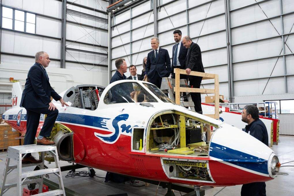 Prime Minister Mark Carney looks at a CT114 Snowbird while touring IMP Aerospace, in Halifax on March 26, 2026.