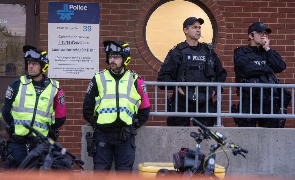 Police watch over anti-police brutality protesters outside Montreal police station 39 in Montreal North during a protest on Monday June 15, 2026.