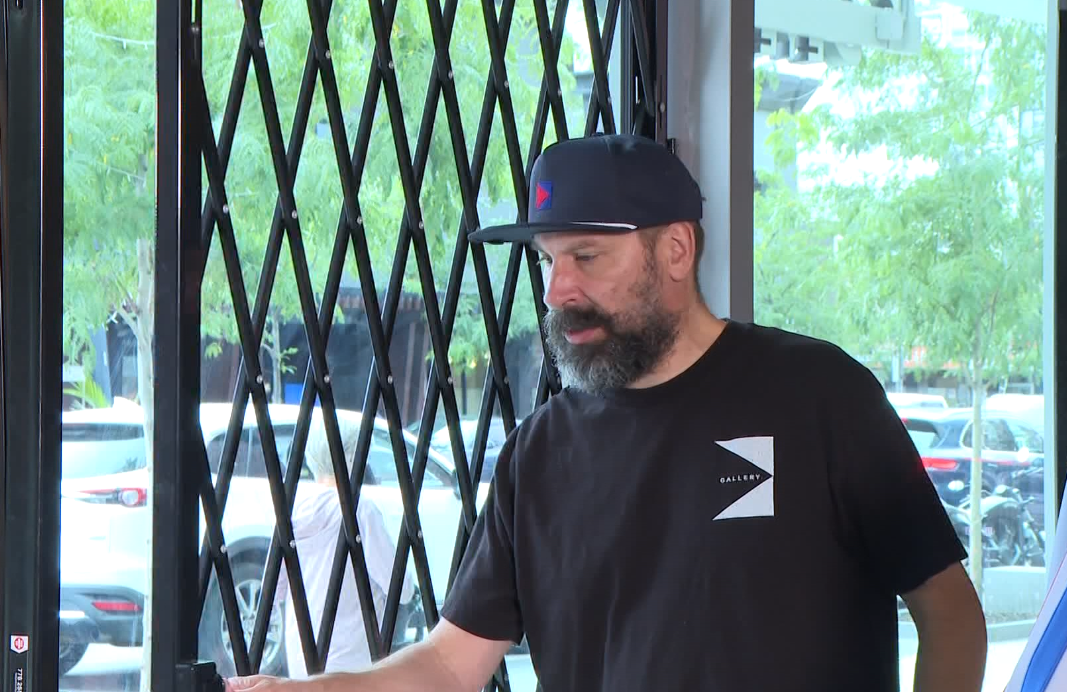Todd Daniels owner of Gallery street clothing, Showing his security gates he bought.