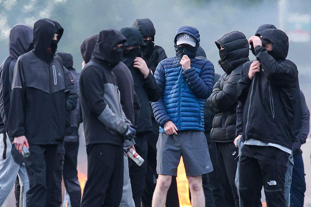 Masked youths block a road with burning debris in north Belfast, Northern Ireland, in the evening of June 9, 2026. Northern Ireland police appealed for calm Tuesday after a stabbing in Belfast allegedly by a Sudanese suspect and captured in a graphic video prompted calls for anti-immigration protests from UK far-right figures.