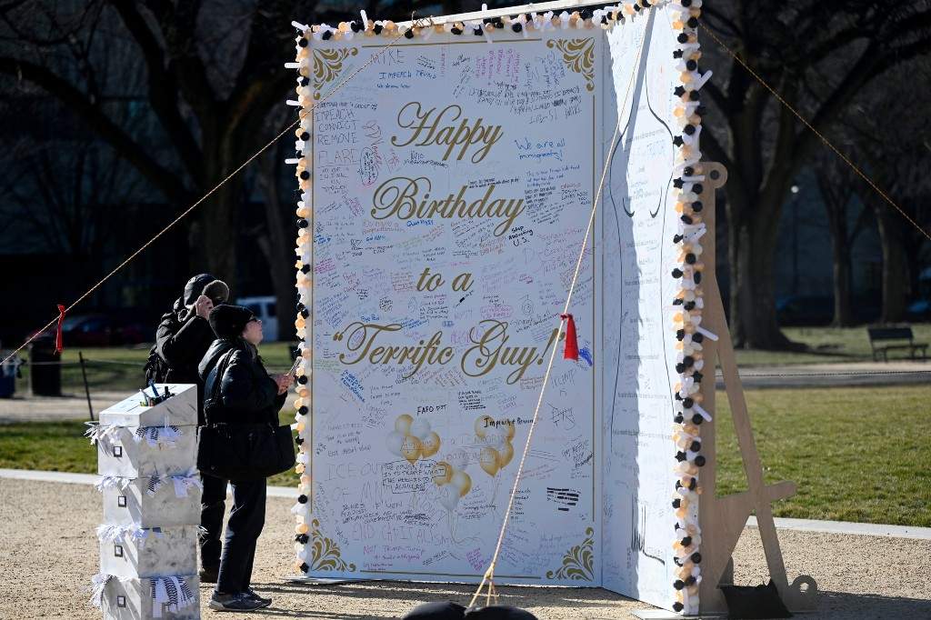 People look at a 10-foot-tall protest art installation, also referred to as the 'The Epstein Birthday card,' at the National Mall near the U.S. Capitol on January 21, 2026 in Washington, DC.