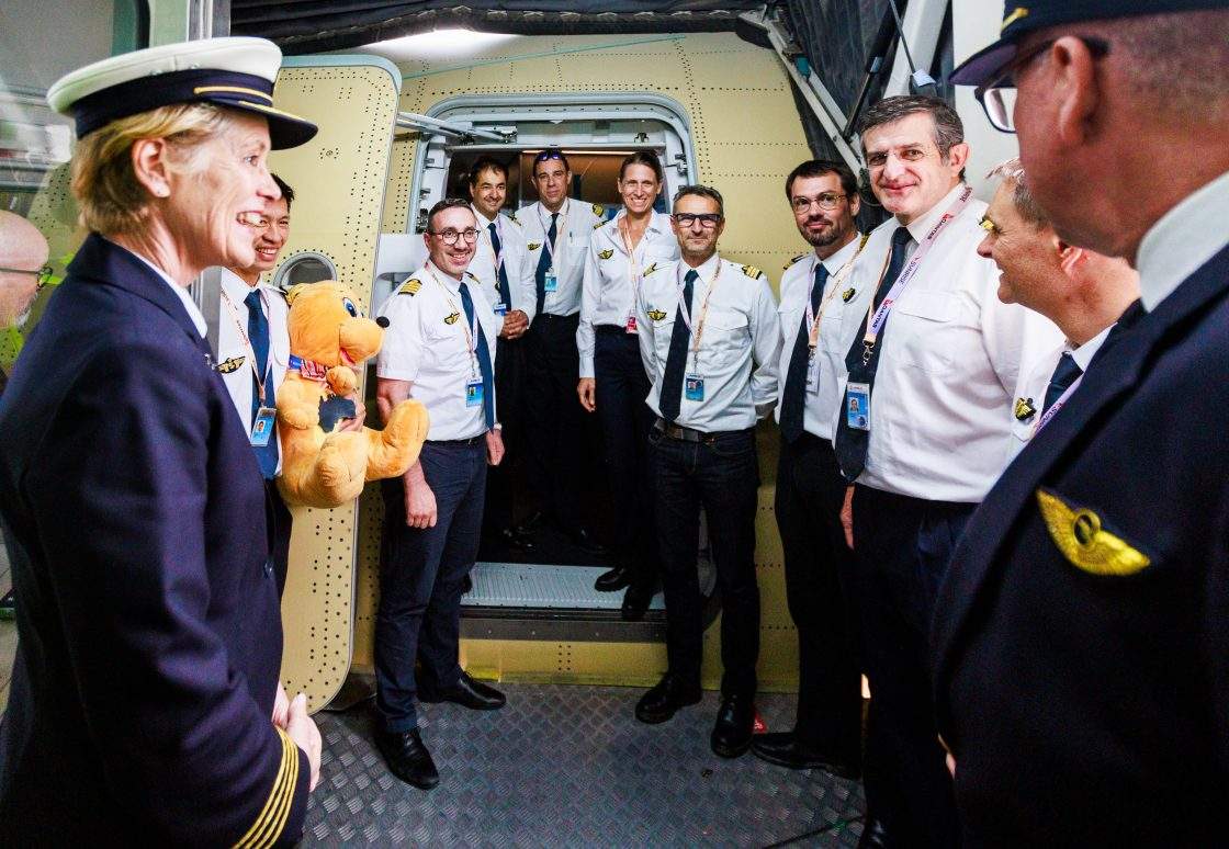 Staff pose at the entrance of Qantas' Airbus A350-1000ULR ahead of a test flight from Toulouse to Sydney.