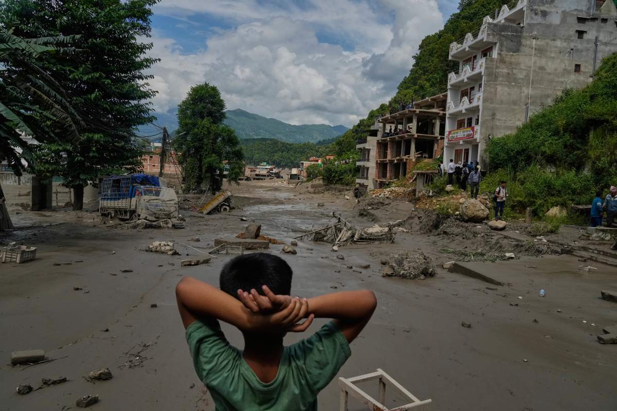 A boy looks at the devastation caused by flash flooding along the Trishuli River in Nepal's Nuwakot district, Wednesday, Aug. 26, 2026. (AP Photo/Niranjan Shrestha)