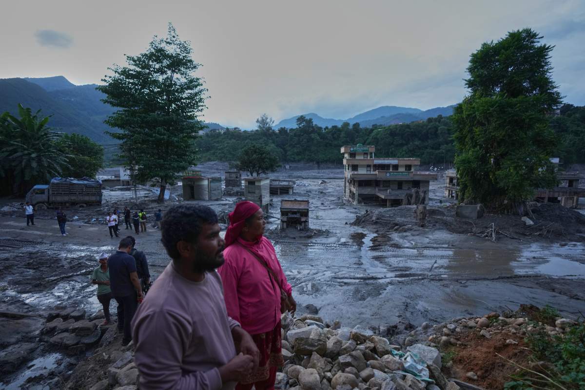 Residents look at the devastation left by flash flooding in Nepal’s Nuwakot district, Thursday, Aug. 27, 2026. (AP Photo/Rajesh Kumar Singh)