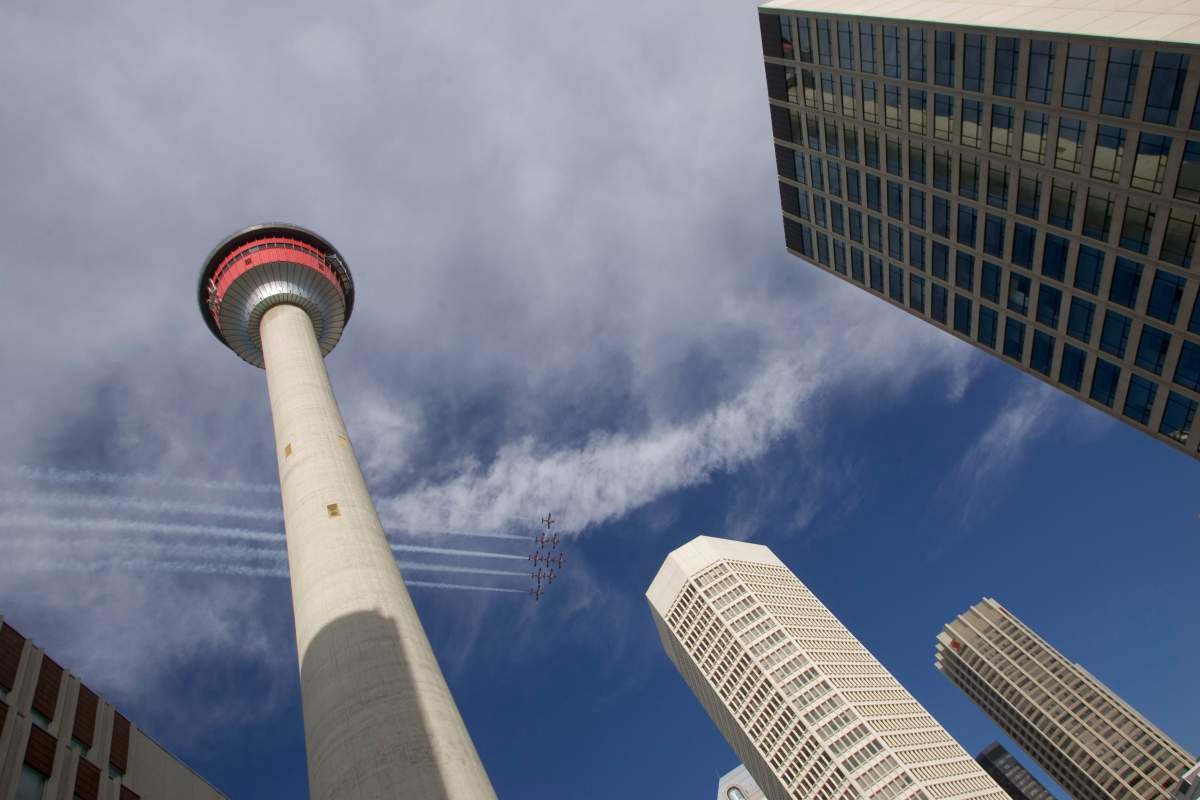 The Snowbirds aerobatic team fly by the Calgary skyline on the first day of the Calgary Stampede.