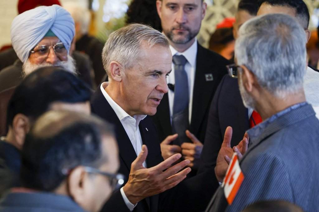 Prime Minister Mark Carney, centre, meets with supporters at a restaurant in Calgary, Thursday, Oct. 15, 2026.