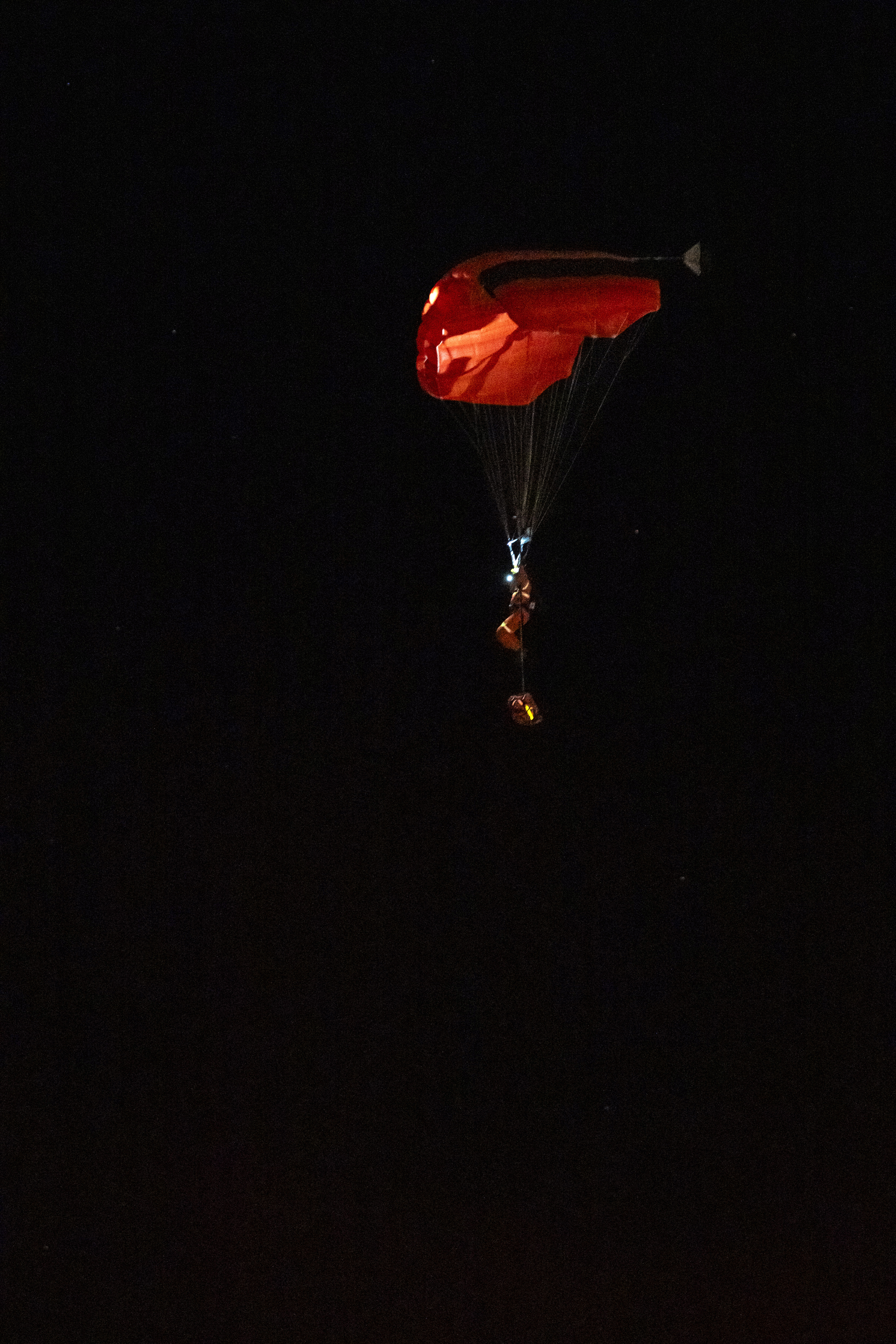 A person parachutes near the Wainwright Health Centre as injured military members are treated after a fire at CFB Wainwright, outside of Wainwright, Alta., on Saturday, Oct. 17, 2026.