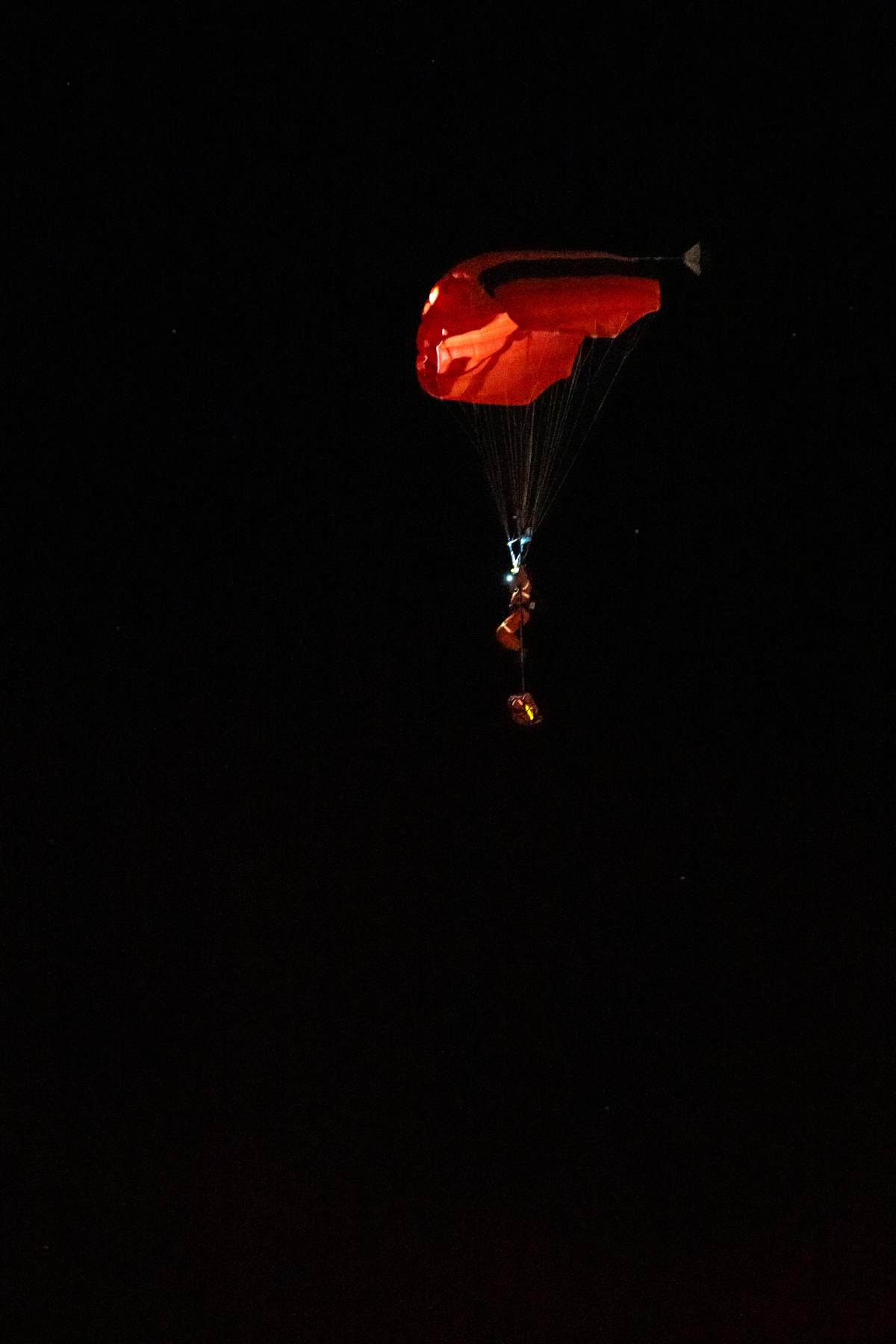 A person parachutes near the Wainwright Health Centre as injured military members are treated after a fire at CFB Wainwright, outside of Wainwright, Alta., on Saturday, Oct. 17, 2026.