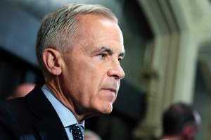 Prime Minister Mark Carney responds to questions from journalists as he makes his way to a meeting of the Liberal caucus, on Parliament Hill in Ottawa, on Wednesday, Oct. 7, 2026. THE CANADIAN PRESS/Justin Tang