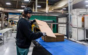 An employee checks the quality of cut as an order of cardboard box packaging is manufactured at Cascades in Drummondville, Que., on Friday, March 27, 2026. THE CANADIAN PRESS/Christinne Muschi