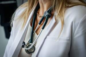 A doctor wears a lab coat and stethoscope in an exam room at a health clinic in Calgary, Friday, July 14, 2023.THE CANADIAN PRESS/Jeff McIntosh