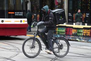 A food delivery courier rides an e-bike in Toronto on Wednesday, January 3, 2024. THE CANADIAN PRESS/Chris Young